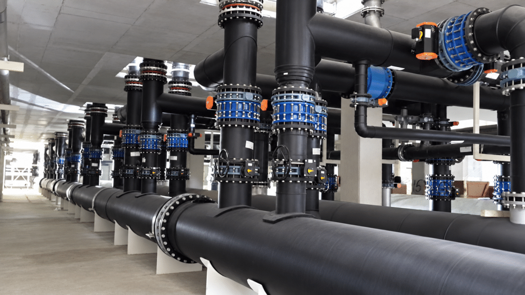 Black plastic pipework and valves in an HVAC mechanical system.